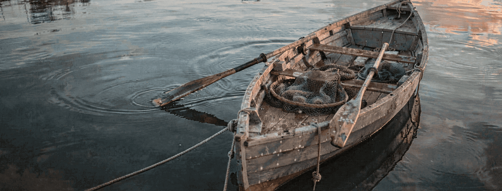 Hölzernes Fischerboot vom Ufer abgestoßen, Bug zum offenen tiefen Wasser.